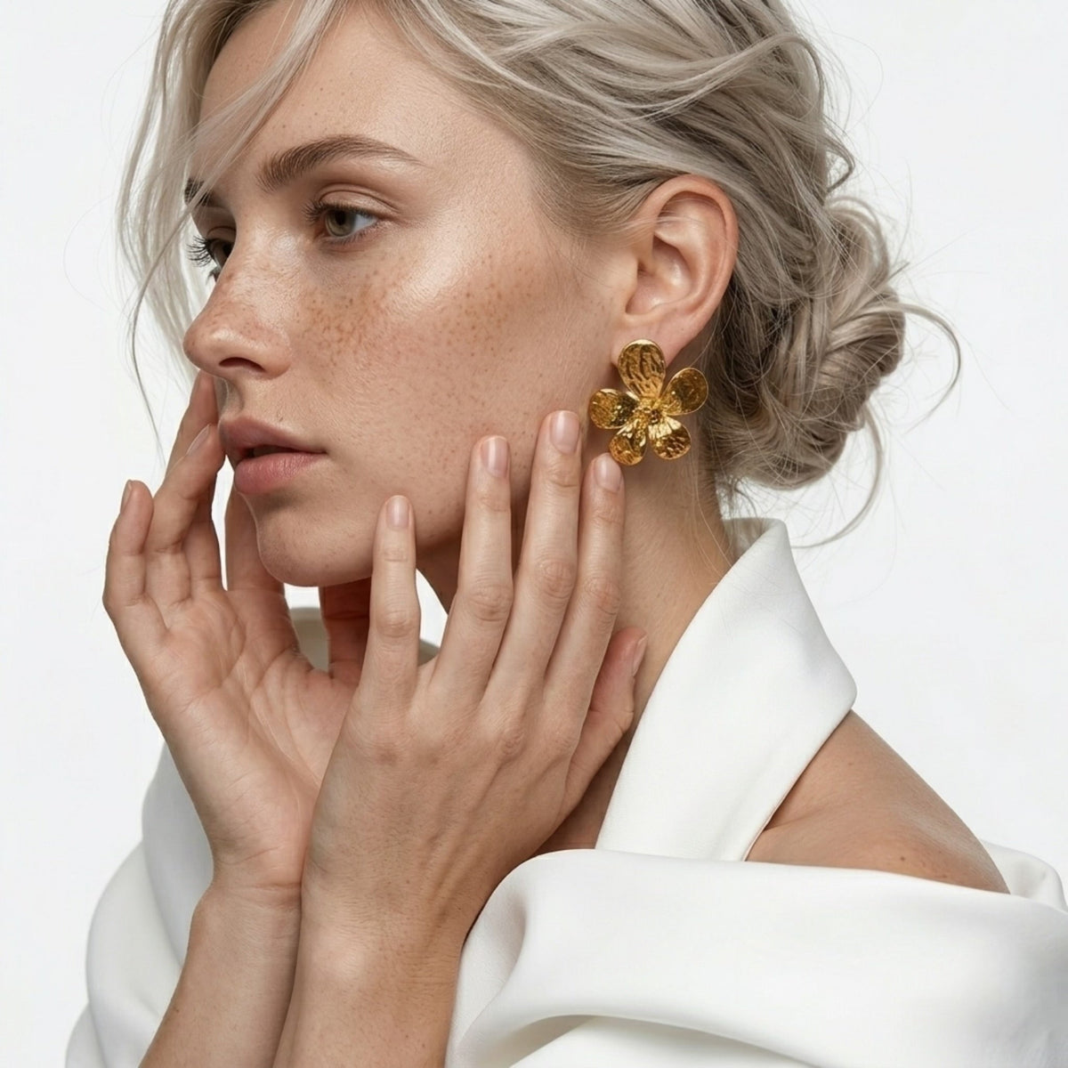 BEHI MILANO Bloom Earrings — frontal portrait of model wearing 18k gold hammered flower stud earrings
