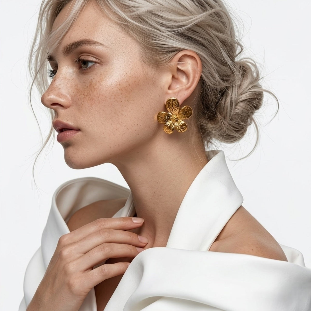 BEHI MILANO Bloom Earrings — profile view of model with blonde updo wearing gold floral statement earrings