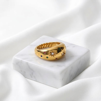 BEHI MILANO Camila Ring — close-up of gold celestial ring on white marble pedestal