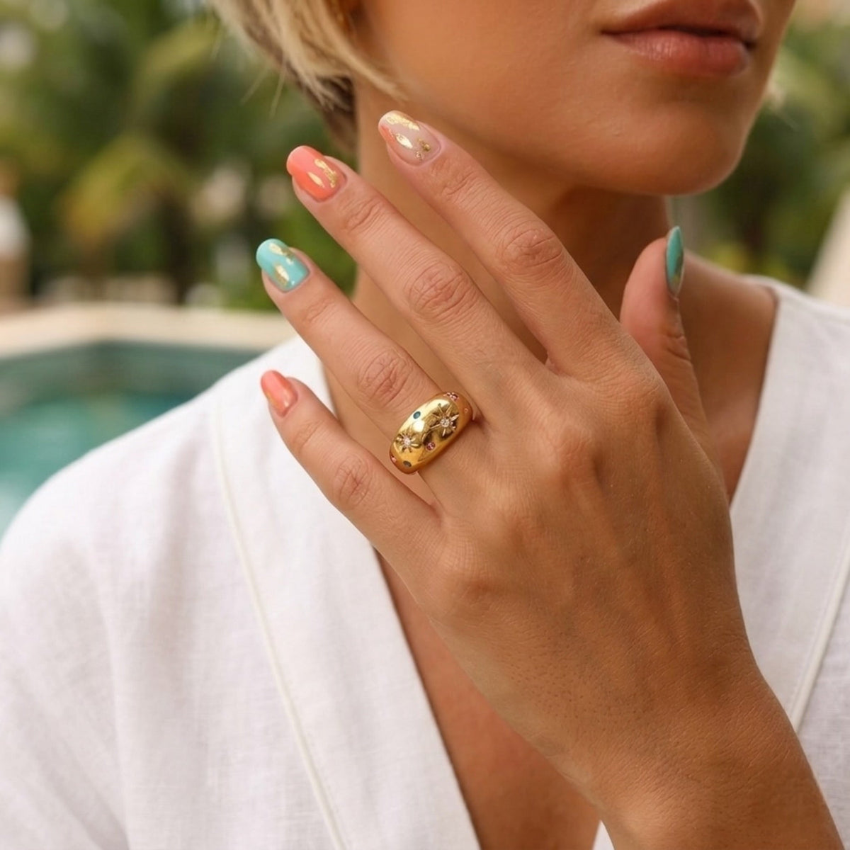 BEHI MILANO Camila Ring — model showing 18k gold starburst dome ring poolside
