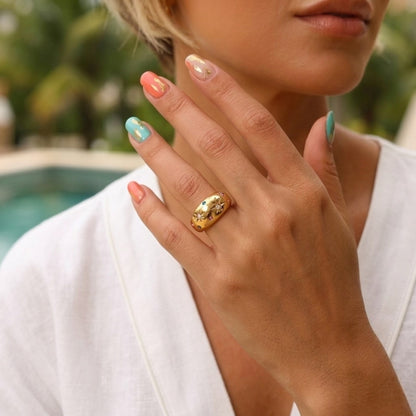 BEHI MILANO Camila Ring — model showing 18k gold starburst dome ring poolside