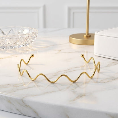 BEHI MILANO Carla Choker — gold wavy neck wire displayed on white marble table