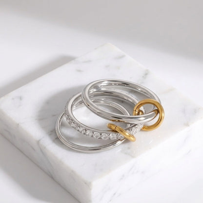 BEHI MILANO Carlita Ring — multi-finger connected ring folded into stack on white marble block