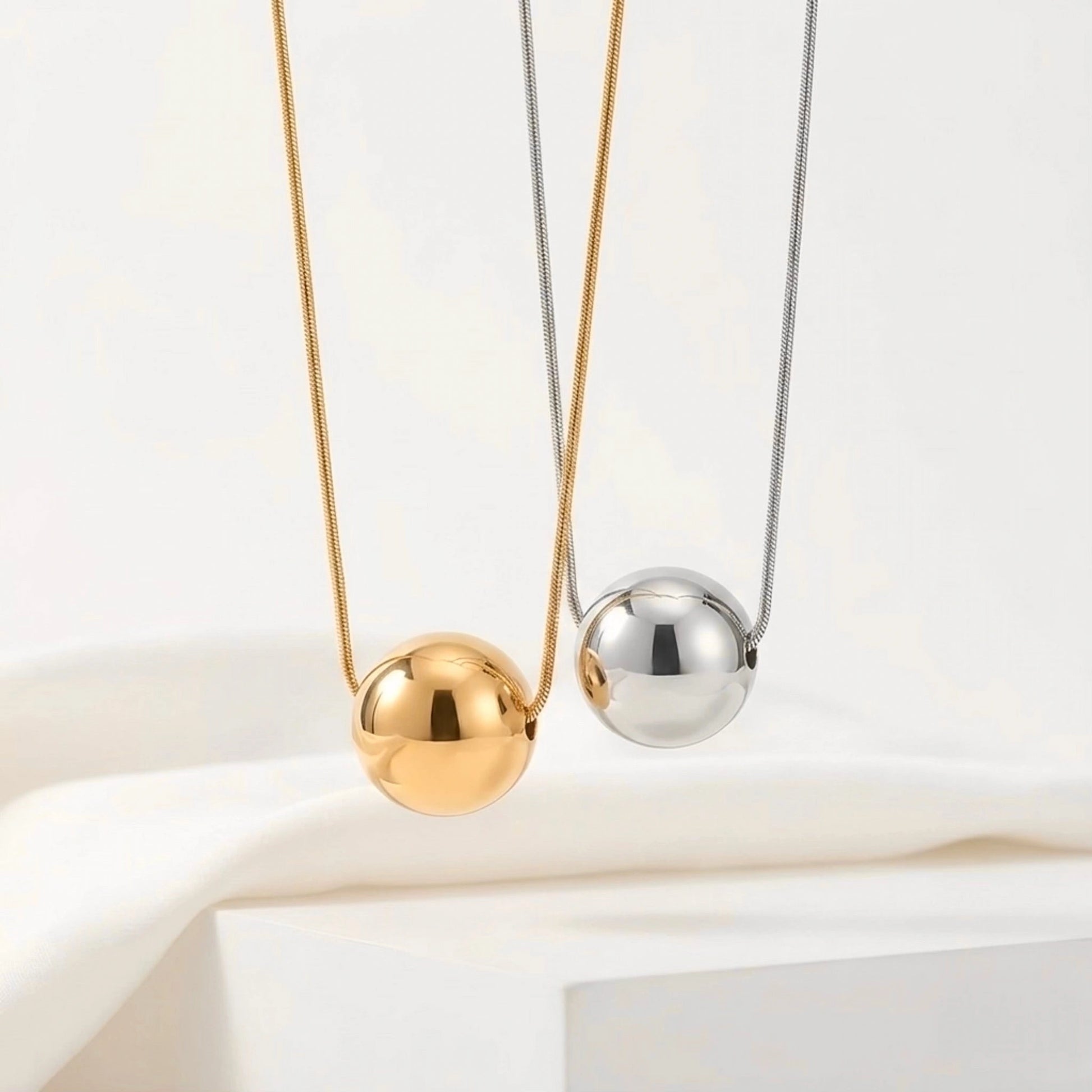 BEHI MILANO Chic Necklace — gold and silver 20mm sphere pendant necklaces on white display