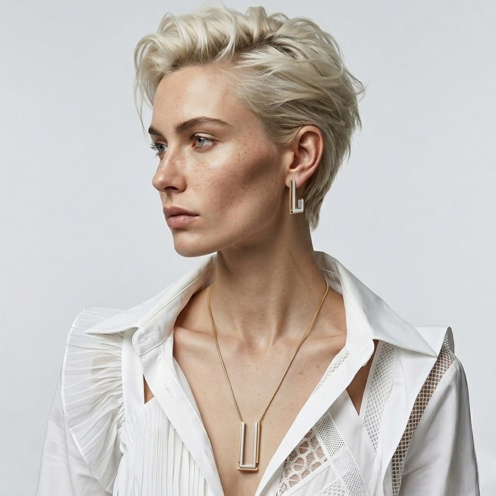 BEHI MILANO Cindy Necklace — model with blonde crop hairstyle wearing two-tone rectangular pendant necklace
