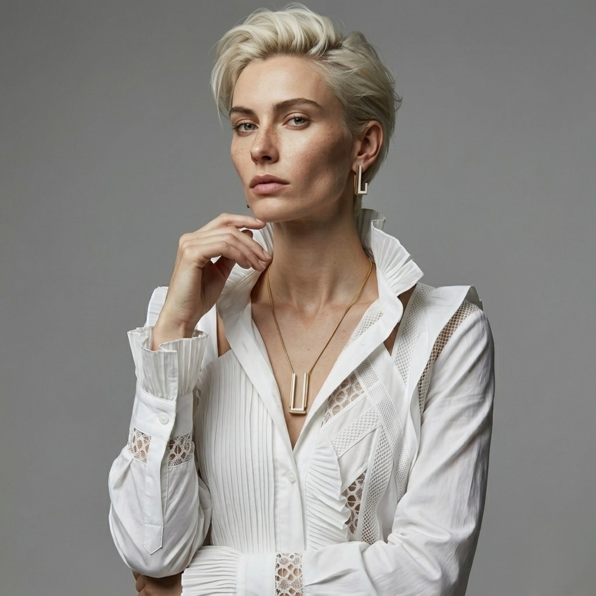 BEHI MILANO Cindy Necklace — model wearing white structured blouse and gold two-tone geometric necklace