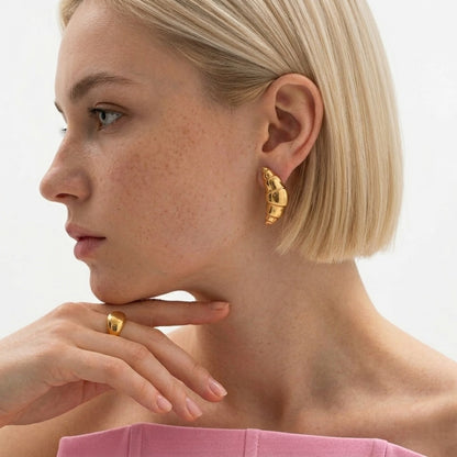BEHI MILANO Cornetto Earrings — side profile of blonde model wearing 18k gold croissant drop earrings