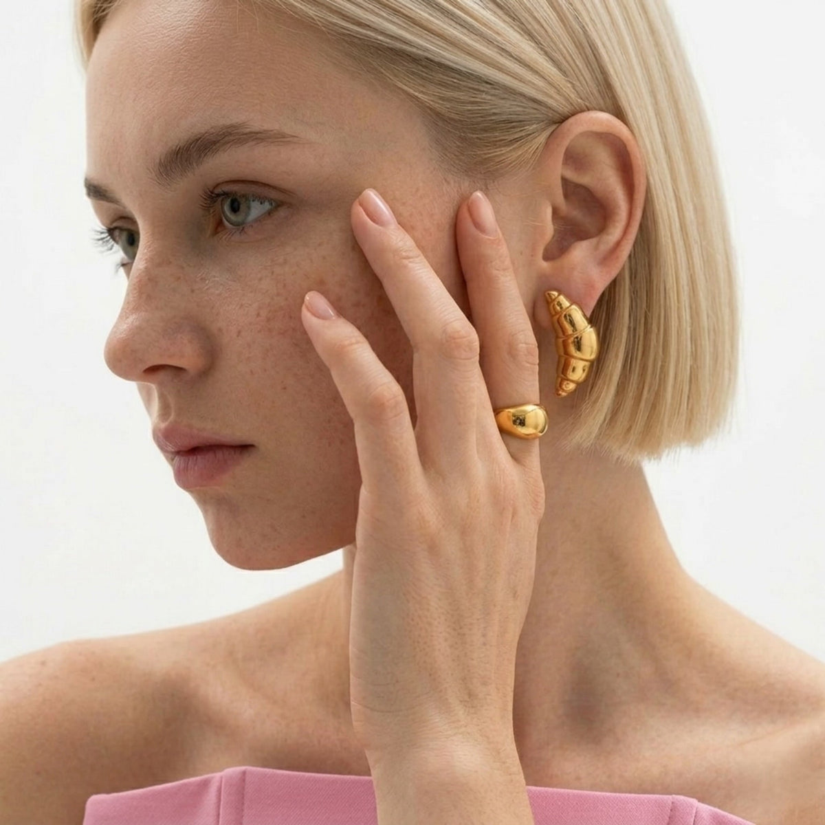 BEHI MILANO Cornetto Earrings — close-up of model wearing gold croissant earrings and matching dome ring