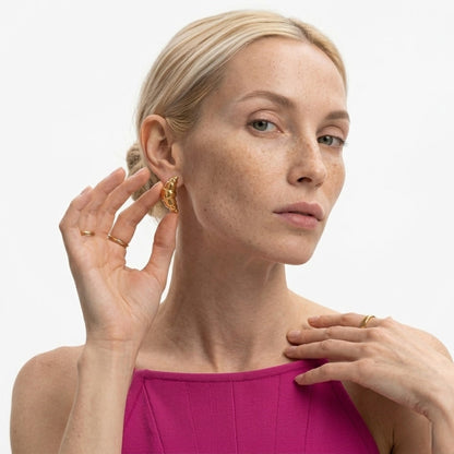 BEHI MILANO Cornetto Earrings — front view of model touching ear wearing gold Italian cornetto studs