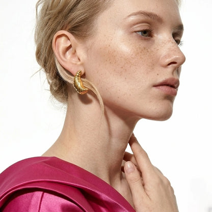 BEHI MILANO Croissant Earrings — close-up of model wearing 18k gold ribbed drop earrings with magenta top