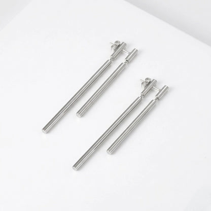 BEHI MILANO Deffi Earrings — silver stainless steel double rod drop earrings on white surface