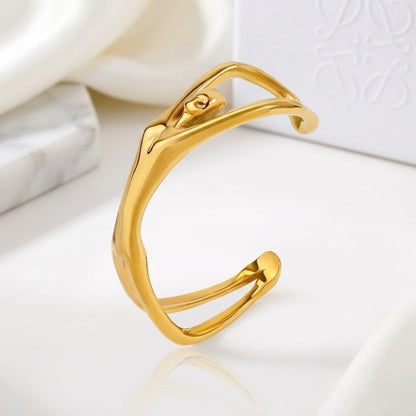 BEHI MILANO Devika Bracelet — gold organic line body cuff displayed on white marble slab