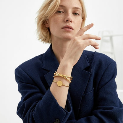 BEHI MILANO Devika Bracelet — model wearing gold abstract body cuff bracelet with navy blazer
