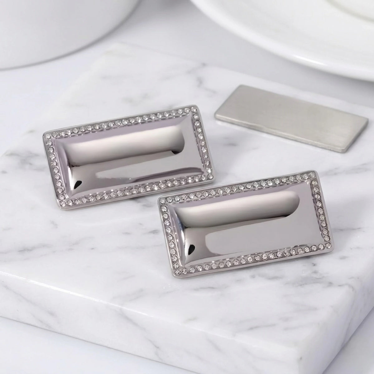 BEHI MILANO Dezi Earrings — silver stainless steel rectangular statement studs with crystal trim on marble