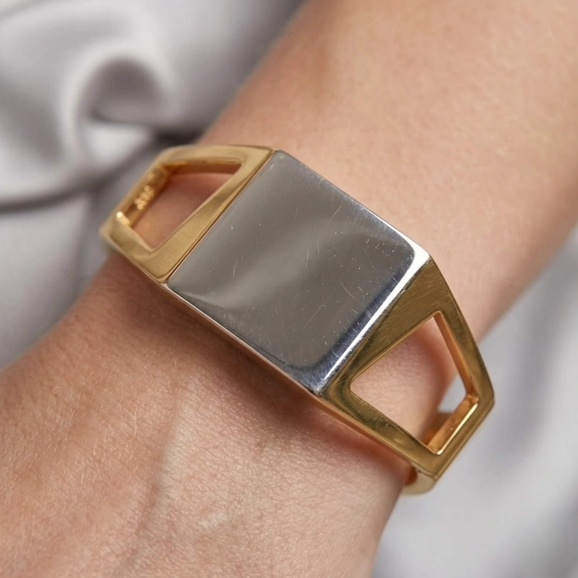 BEHI MILANO Dimitra Bracelet — close-up of gold and silver two-tone cuff bracelet on wrist