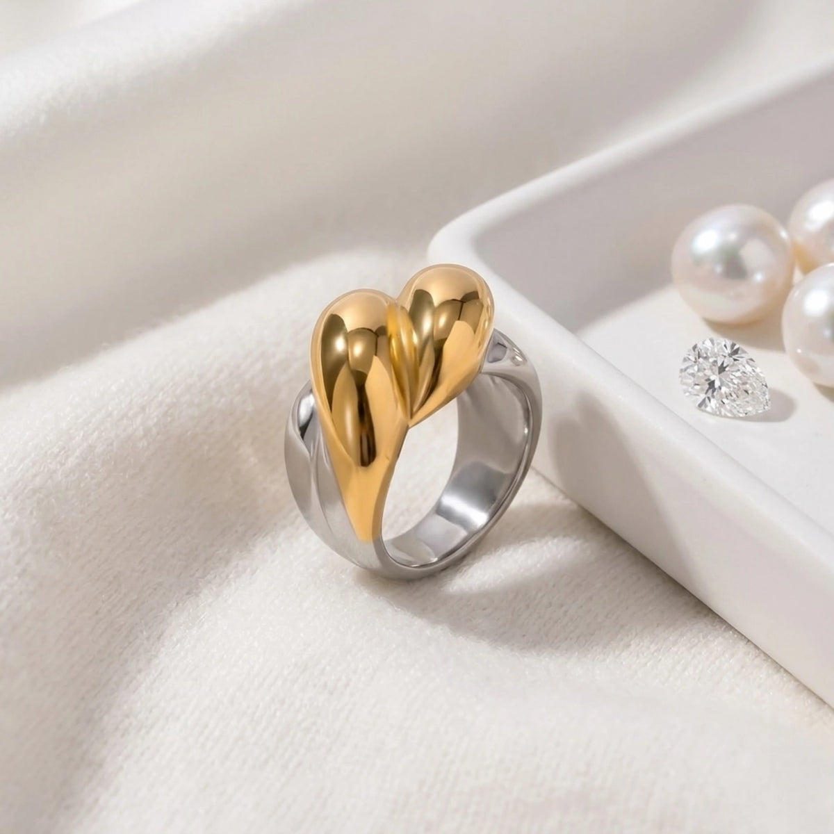 BEHI MILANO Disha Ring — two-tone gold and silver ring displayed next to white ceramic dish with pearls