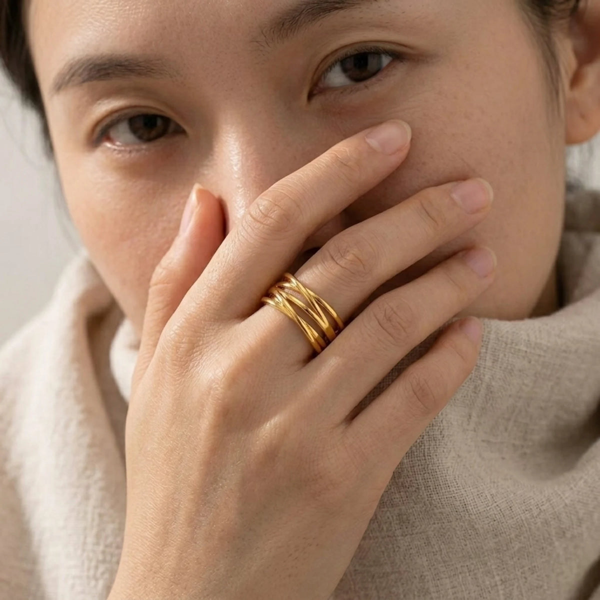 BEHI MILANO Eden Ring — model wearing gold multi-band ring with beige sweater