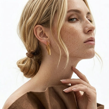 BEHI MILANO Elif Earrings — close-up portrait of model wearing 18k gold geometric earrings