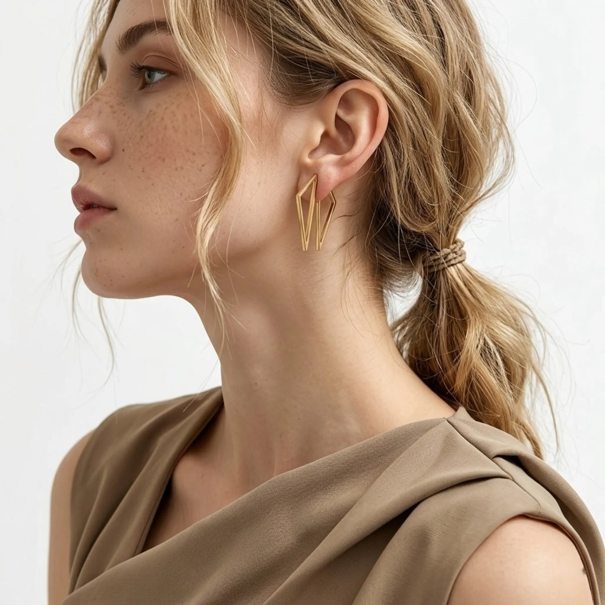 BEHI MILANO Elif Earrings — side view portrait of model displaying gold architectural drop earrings