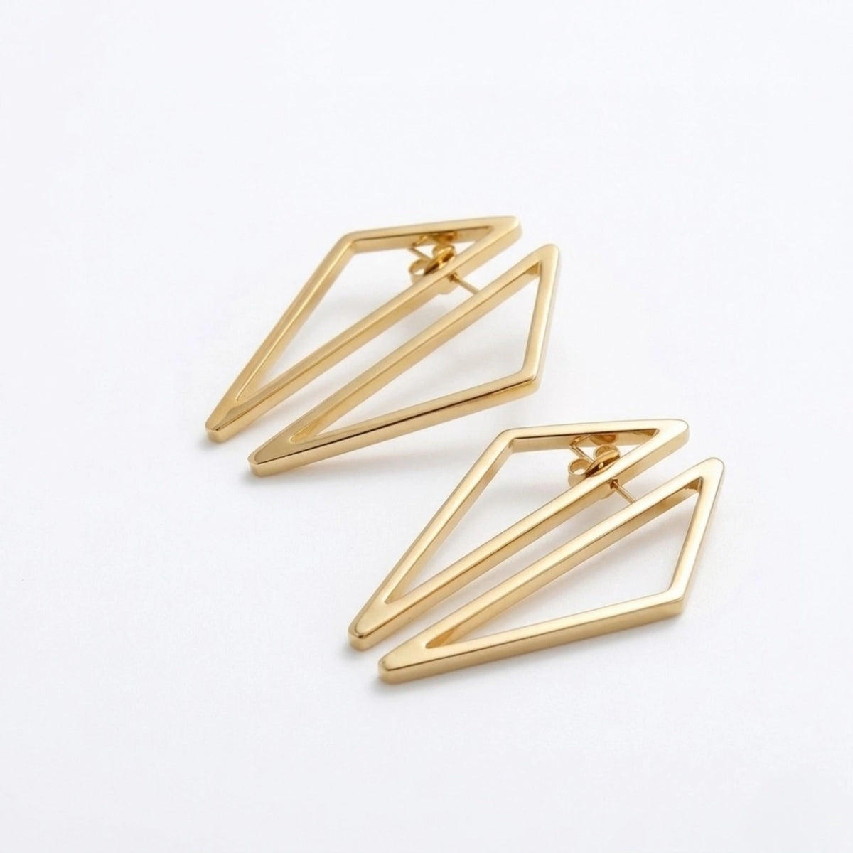 BEHI MILANO Elif Earrings — overhead shot of 18k gold polygonal geometric open framework earrings