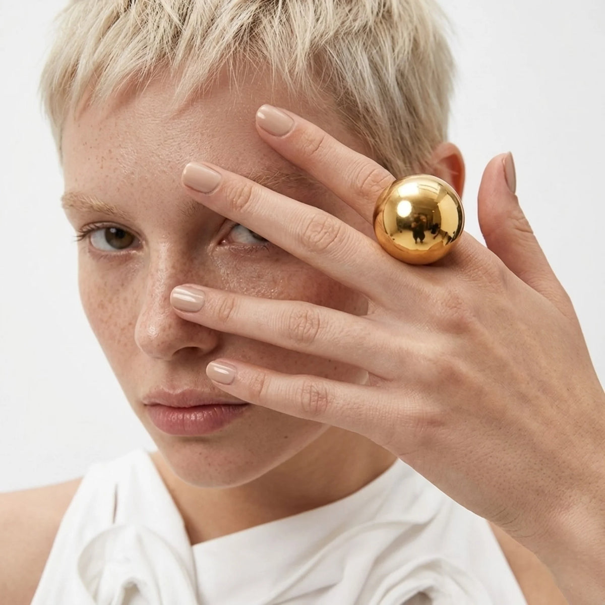 BEHI MILANO Elika Ring — blonde model wearing oversized gold sphere ring on finger