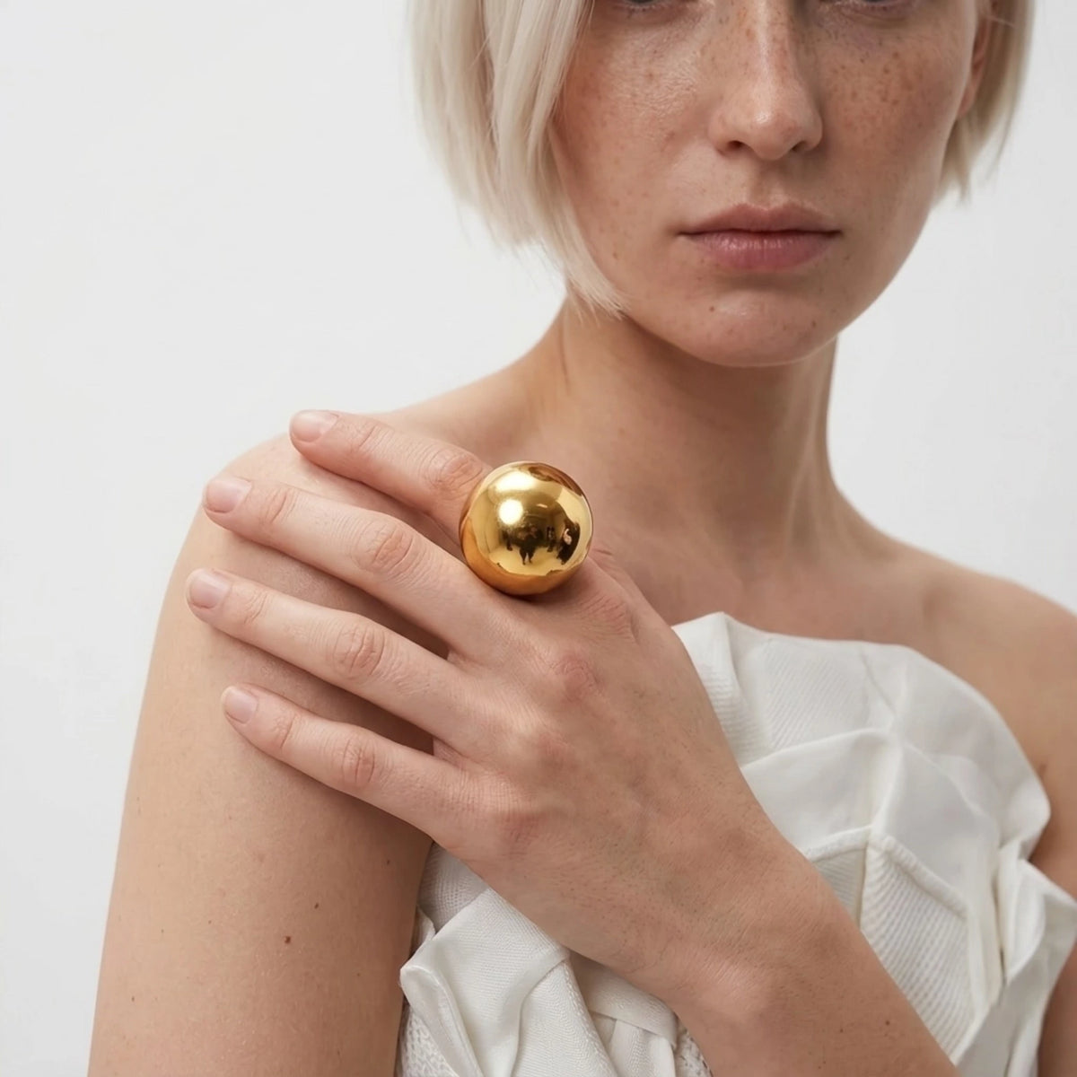 BEHI MILANO Elika Ring — close-up portrait of model displaying high-shine gold sphere ring