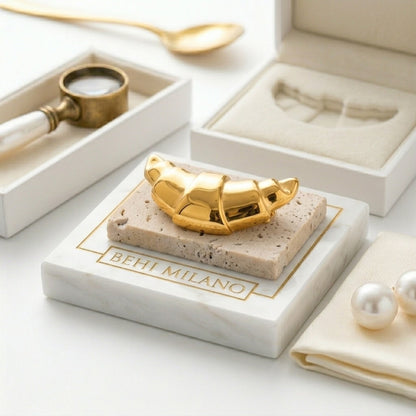 BEHI MILANO Elisa Brooch — top view of gold croissant brooch on marble display