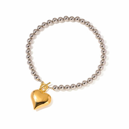 BEHI MILANO Emma Choker — 18k gold puffy heart pendant on silver beaded necklace on white background