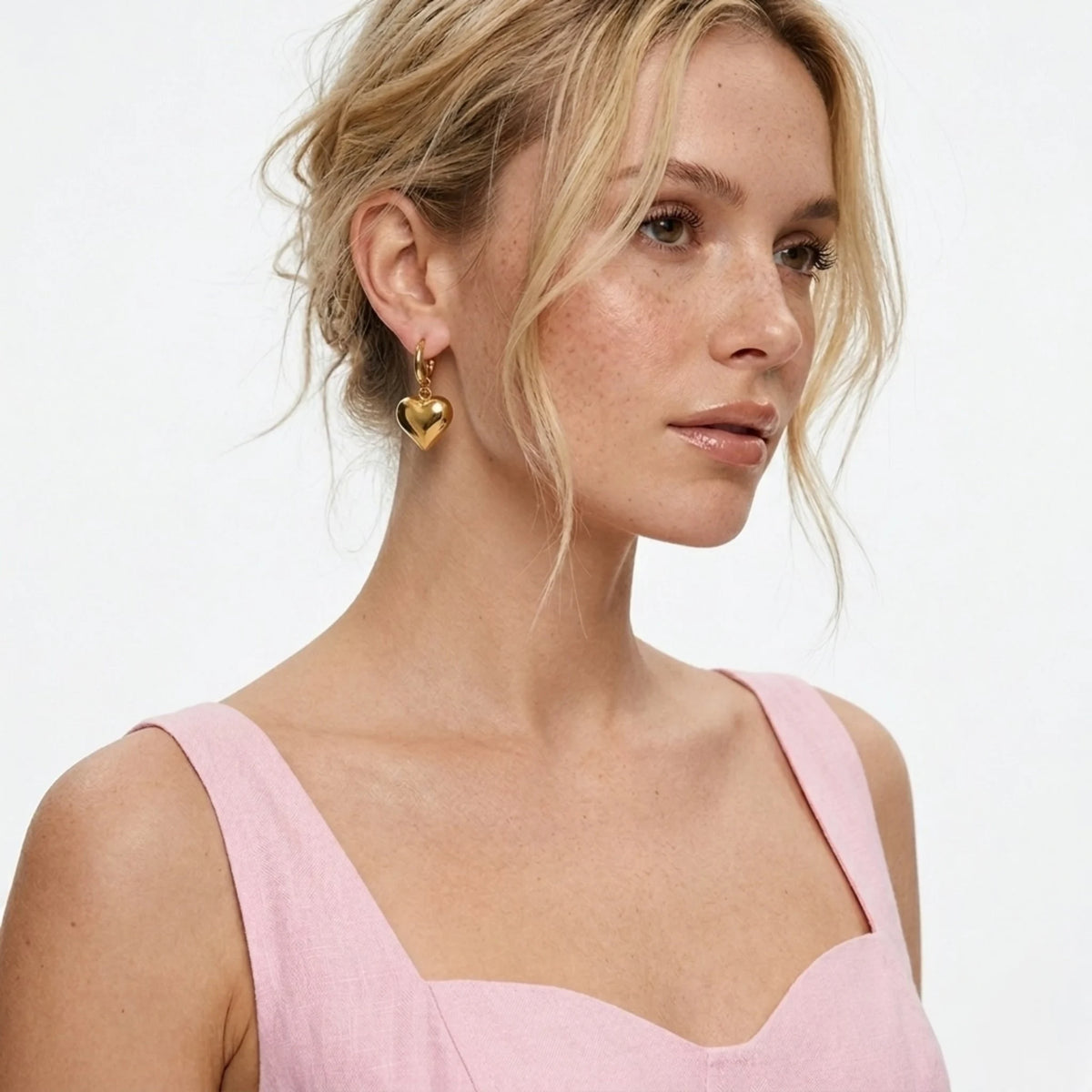 BEHI MILANO Emma Earrings — side profile of model wearing 18k gold puffy heart drop hoop earrings