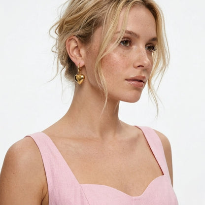 BEHI MILANO Emma Earrings — side profile of model wearing 18k gold puffy heart drop hoop earrings