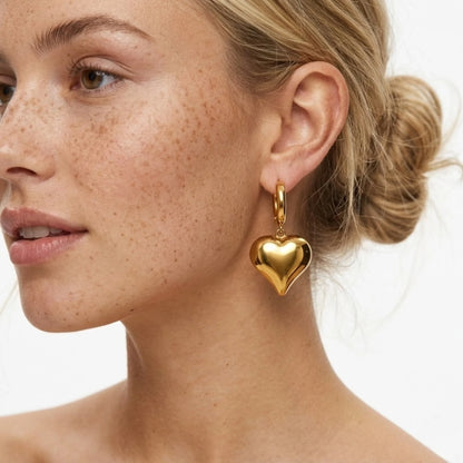 BEHI MILANO Emma Hoop Earrings — close-up of model wearing gold puffy heart drop hoop earring