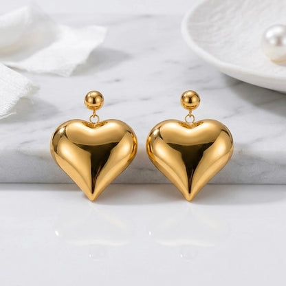 BEHI MILANO Emma XL Earrings — gold puffy heart statement drop earrings displayed on studio tray