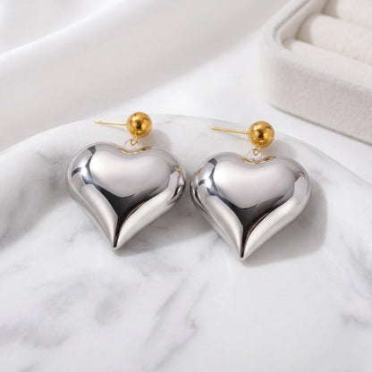 BEHI MILANO Emma XL Earrings — silver puffy heart earrings with gold studs displayed on white marble