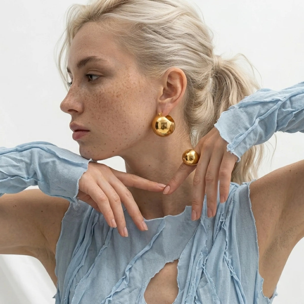 BEHI MILANO Erika Earrings — model styling oversized 18k gold spherical dome statement earrings