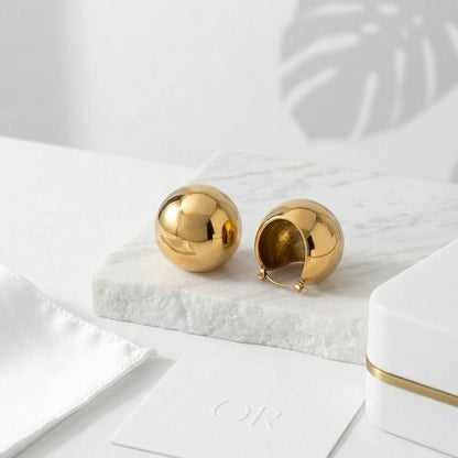 BEHI MILANO Erika Earrings — 18k gold chunky dome statement earrings front view on marble