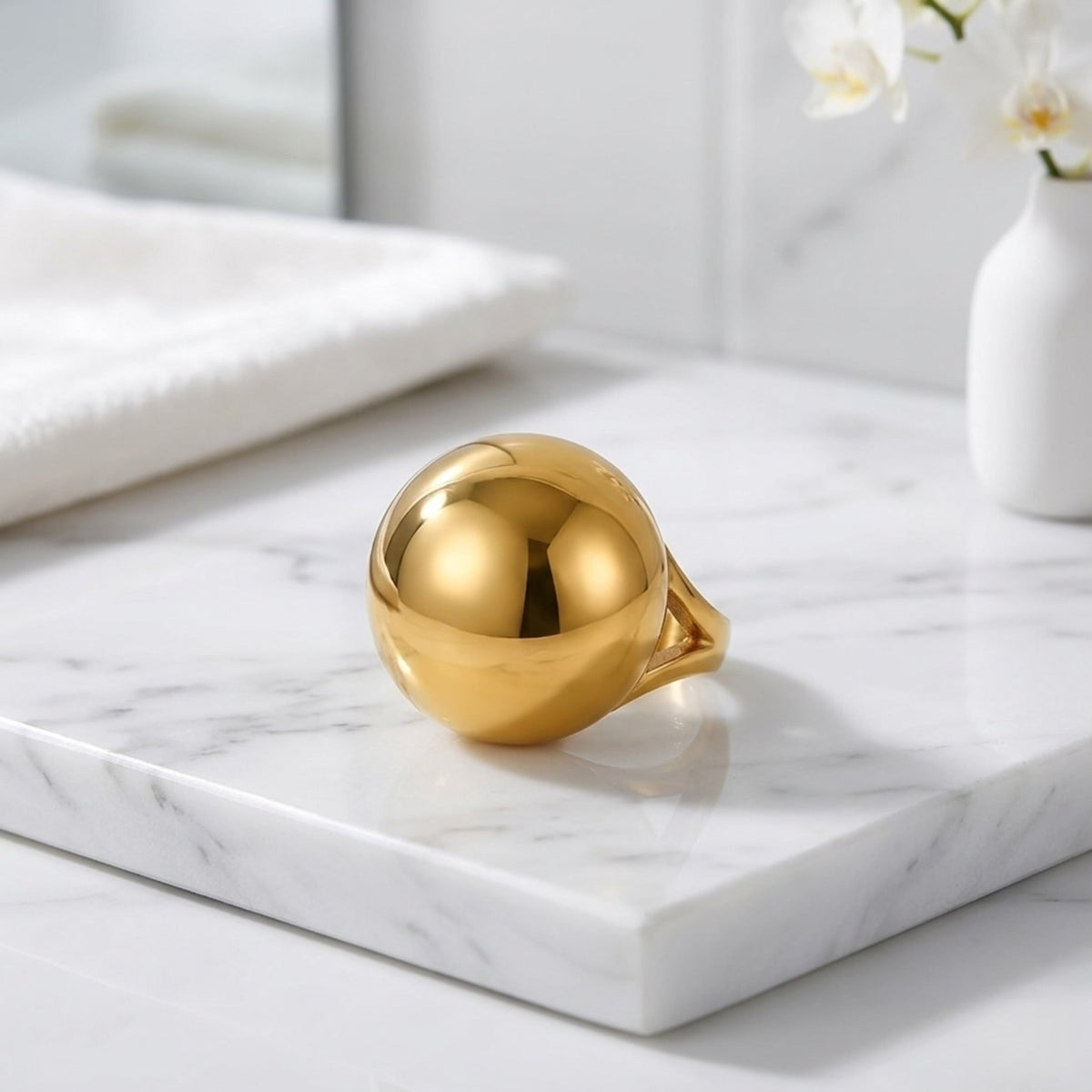 BEHI MILANO Erika Ring — gold chunky sphere dome ring displayed on white marble slab