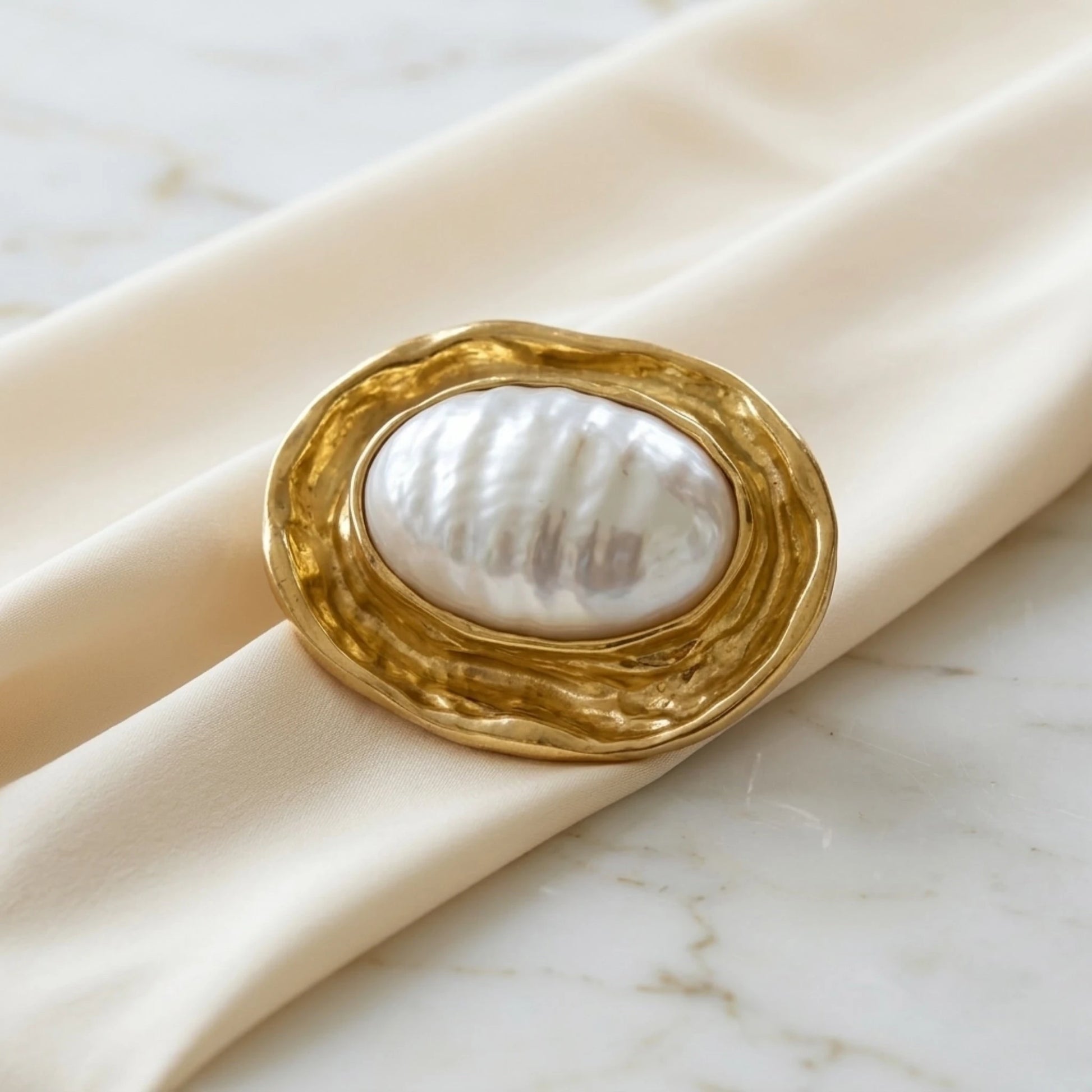 BEHI MILANO Everly Brooch — 18k gold ribbed pearl brooch angle view on luxury silk fabric
