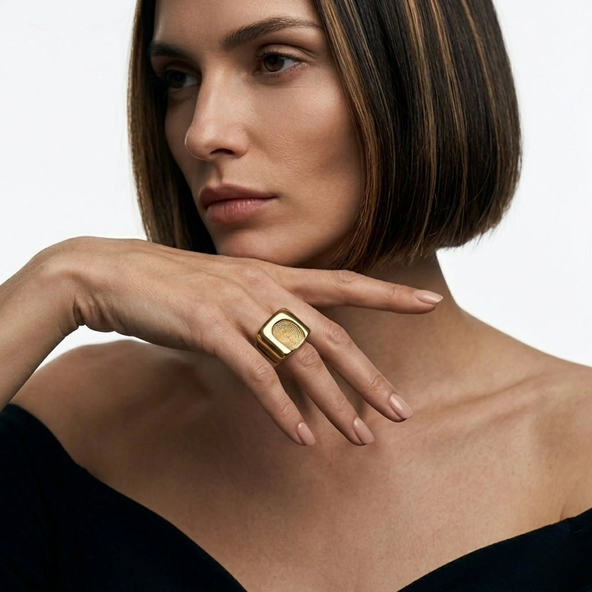 BEHI MILANO Fingerprint Ring — model showcasing gold statement ring with black off-shoulder dress