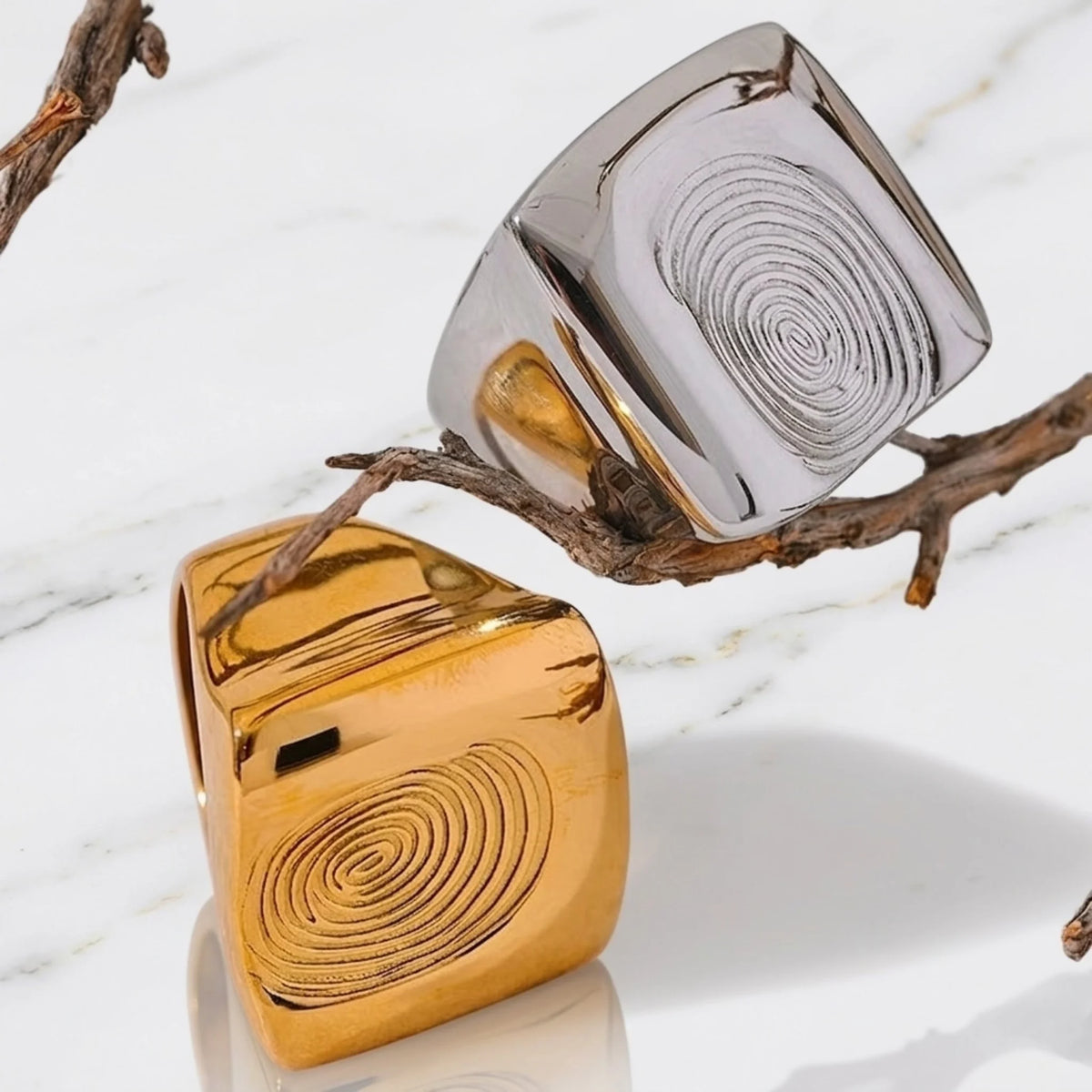 BEHI MILANO Fingerprint Ring — gold and silver fingerprint statement rings close-up on marble surface