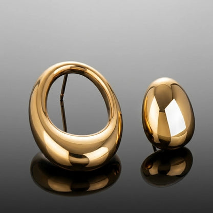 BEHI MILANO Fiona Earrings — gold asymmetric sculptural loop and dome stud on dark glossy background