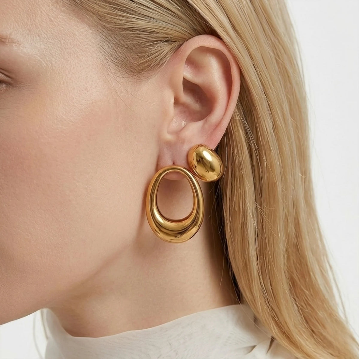 BEHI MILANO Fiona Earrings — close-up of model ear showing 18k gold oval loop and solid dome stud