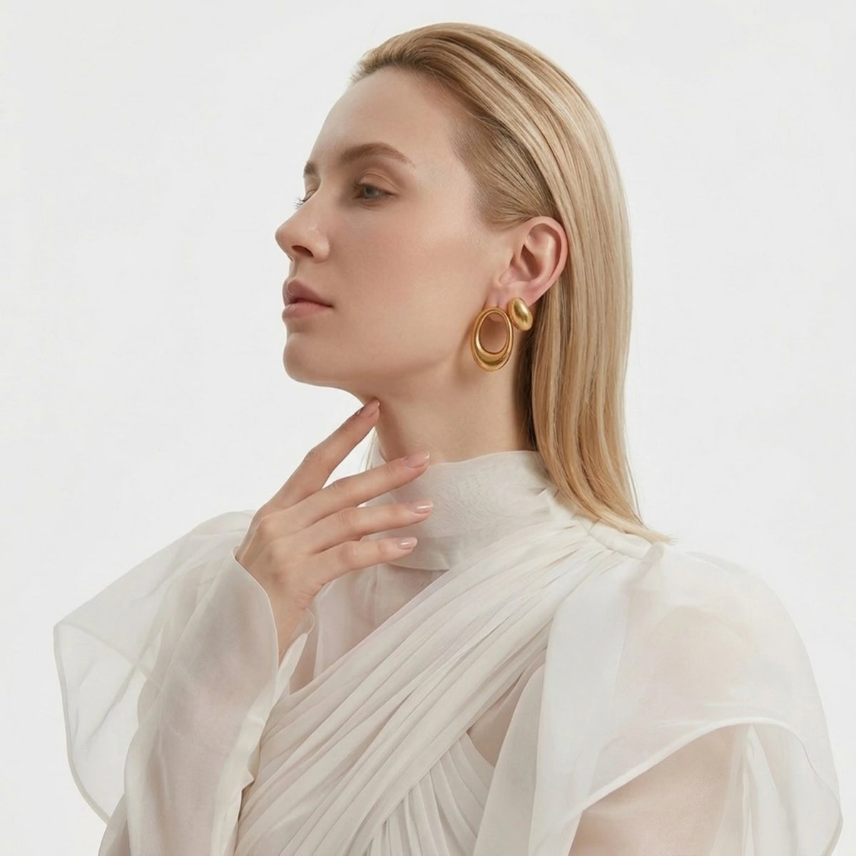BEHI MILANO Fiona Earrings — model portrait displaying gold asymmetric drop earrings