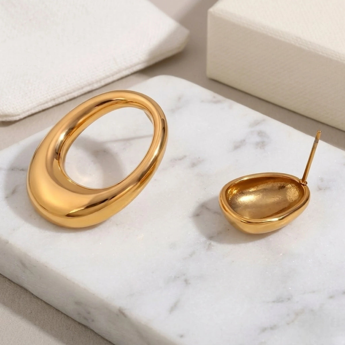 BEHI MILANO Fiona Earrings — gold open loop and solid dome earrings on white marble tray