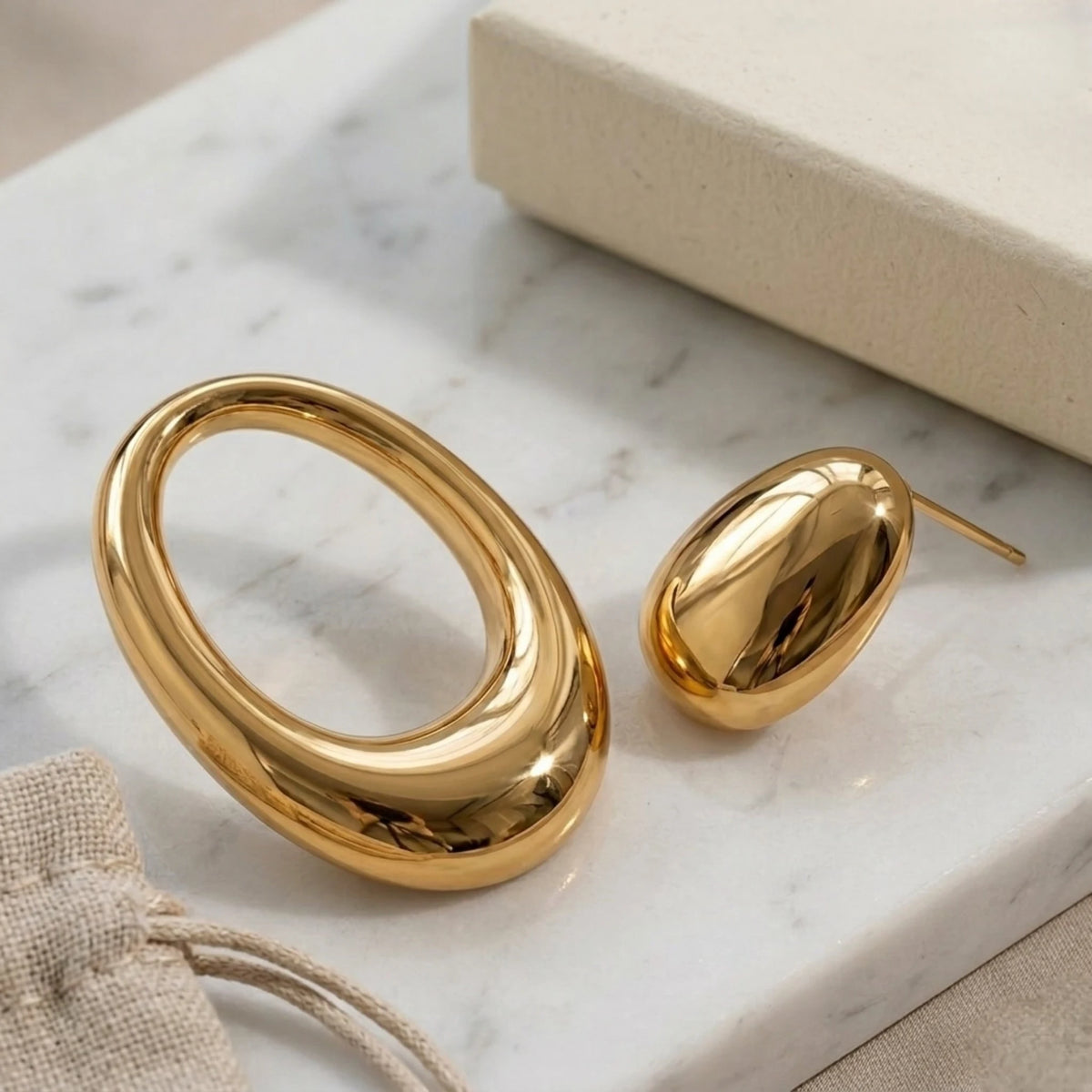 BEHI MILANO Fiona Earrings — 18k gold sculptural earrings with pouch on white marble