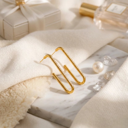 BEHI MILANO Floriana Earrings — gold drop earrings on cream textured knit fabric with loose pearls