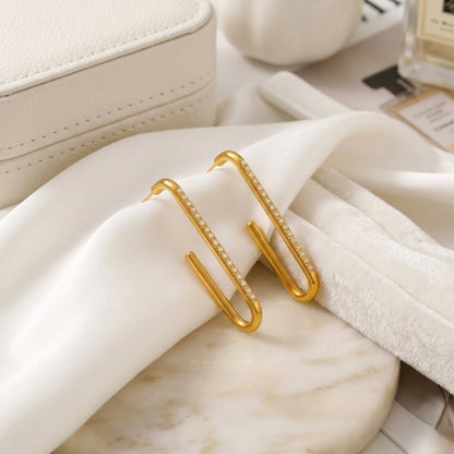BEHI MILANO Floriana Earrings — gold elongated pearl hoop earrings resting on draped white silk