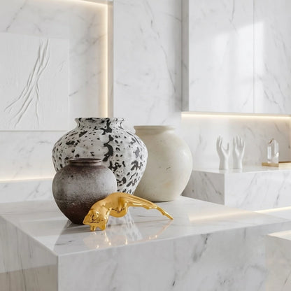 BEHI MILANO Galina Brooch — gold artistic figure brooch on white marble ledge with ceramic vases