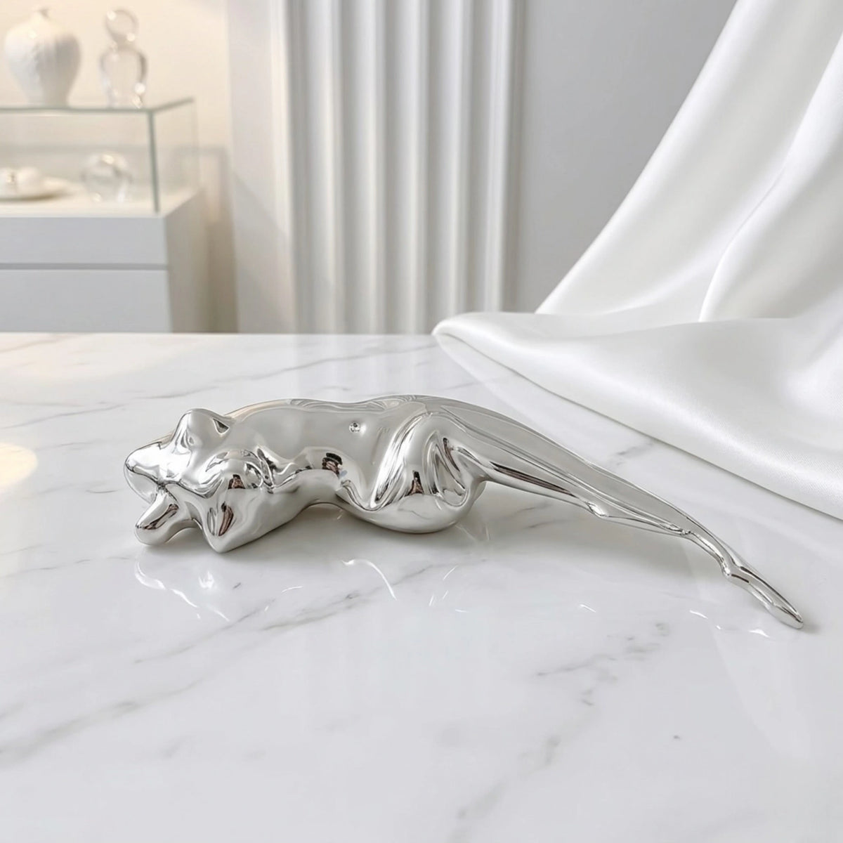 BEHI MILANO Galina Brooch — silver sculptural figure brooch displayed on white marble next to satin fabric