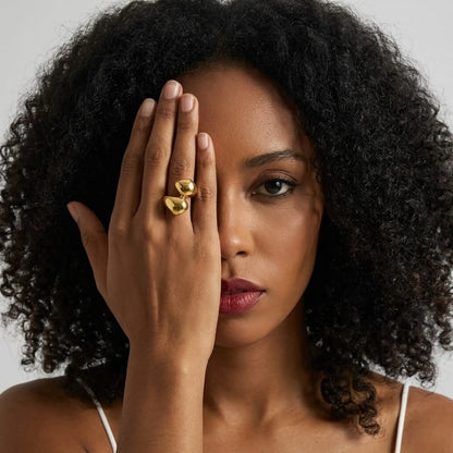 BEHI MILANO Garlita Ring — model with dark curly hair wearing gold organic statement ring on index finger