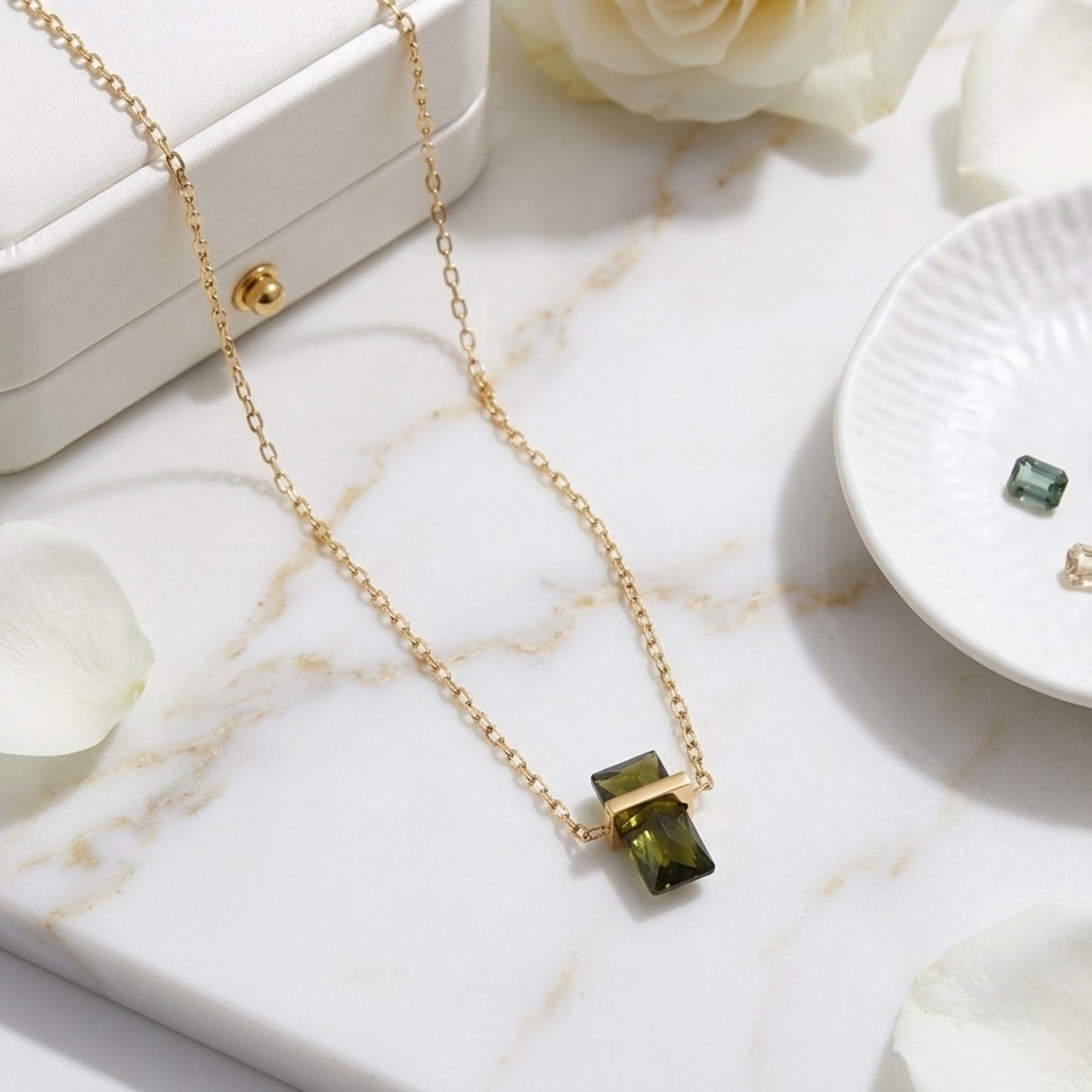 BEHI MILANO Glinka Necklace — green rectangular zircon necklace on white marble dish